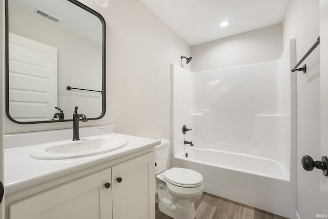 full bathroom with hardwood / wood-style floors, shower / bath combination, toilet, and vanity