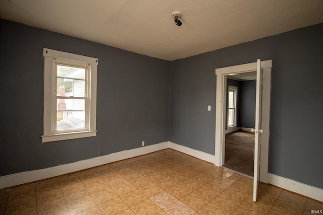 unfurnished room featuring a textured ceiling