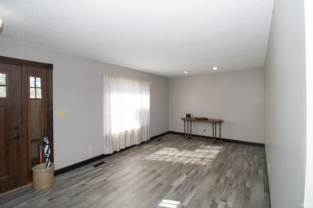 entryway with hardwood / wood-style floors and a textured ceiling