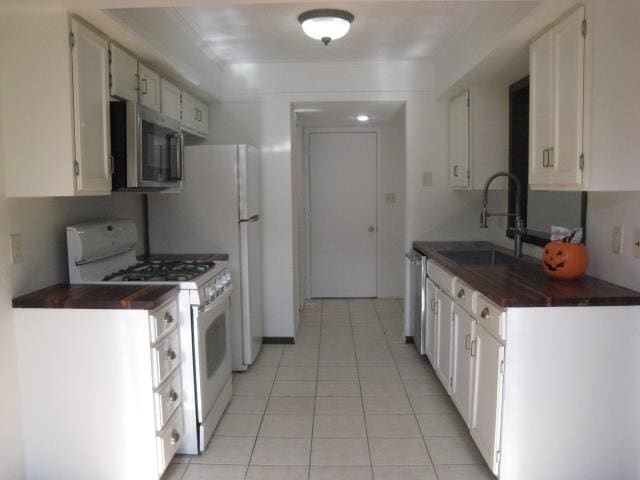 kitchen with sink, white cabinetry, stainless steel appliances, and light tile patterned flooring