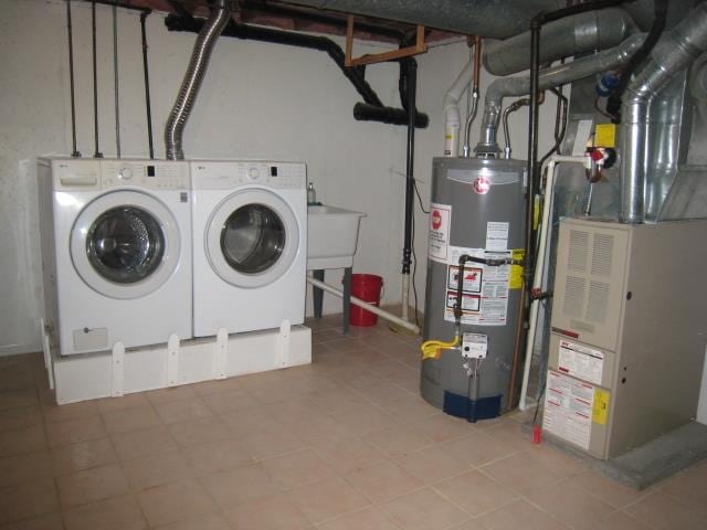 laundry area with water heater, heating unit, and separate washer and dryer