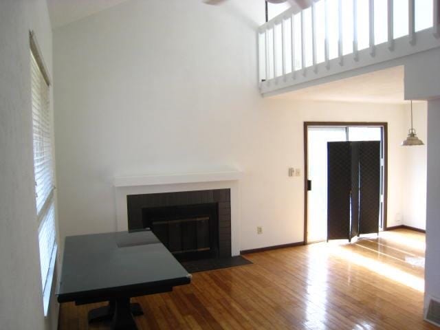 living room with wood-type flooring and a towering ceiling