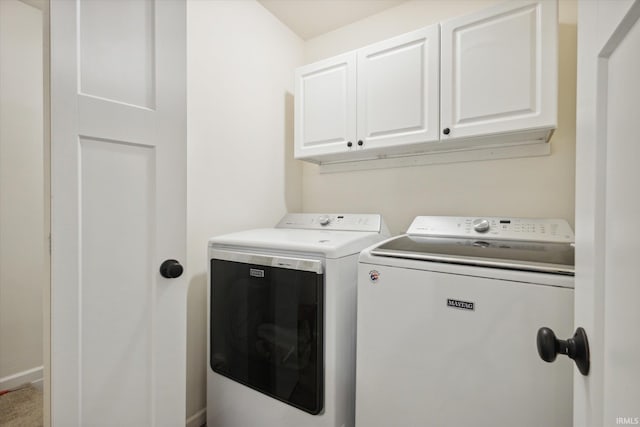 laundry room with washing machine and clothes dryer and cabinets