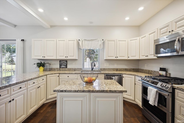 kitchen featuring light stone counters, beamed ceiling, dark wood-type flooring, sink, and stainless steel appliances