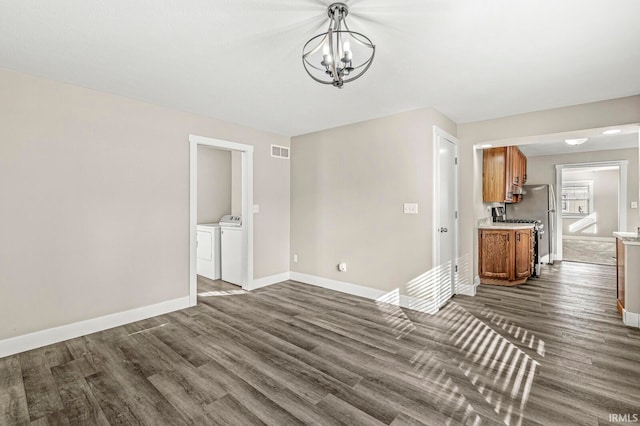 interior space featuring a chandelier, washer and clothes dryer, and dark hardwood / wood-style flooring