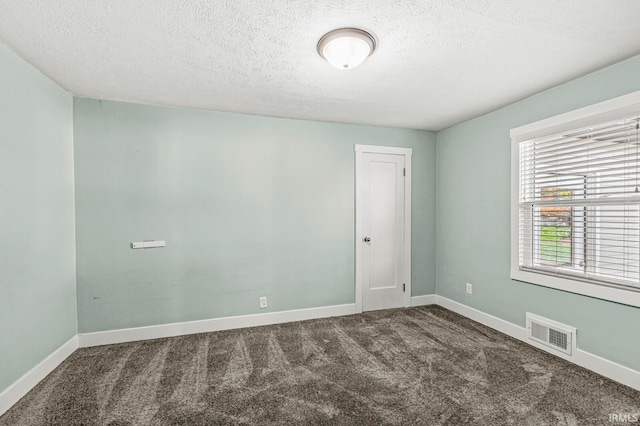 carpeted spare room with a textured ceiling