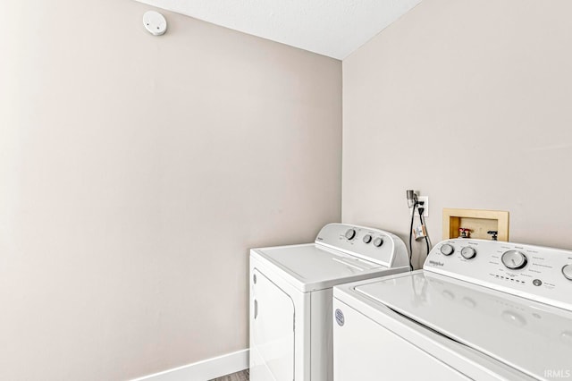 clothes washing area with a textured ceiling and washing machine and clothes dryer