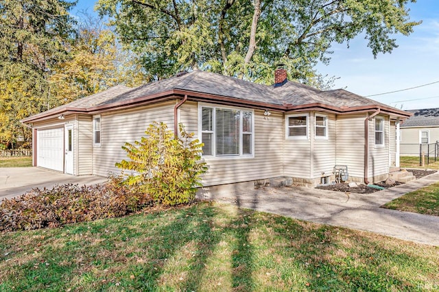 view of side of home featuring a garage and a lawn