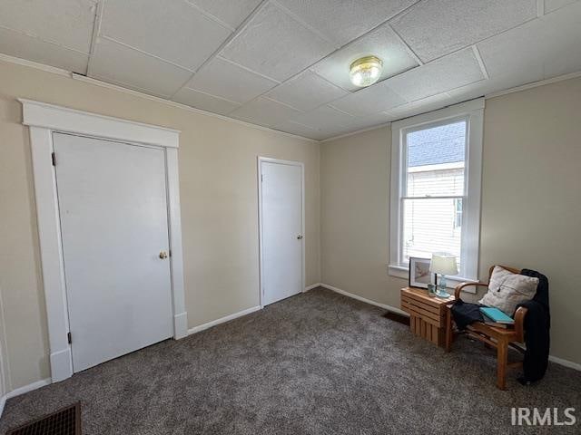 unfurnished room featuring dark colored carpet and ornamental molding