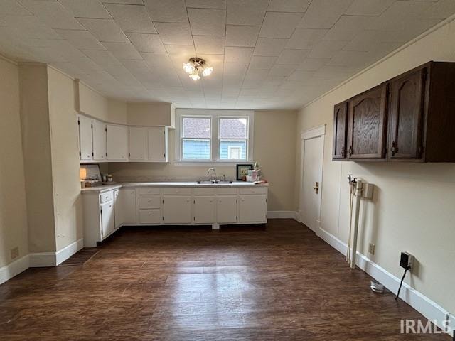 kitchen featuring white cabinets, dark brown cabinets, dark hardwood / wood-style flooring, and sink