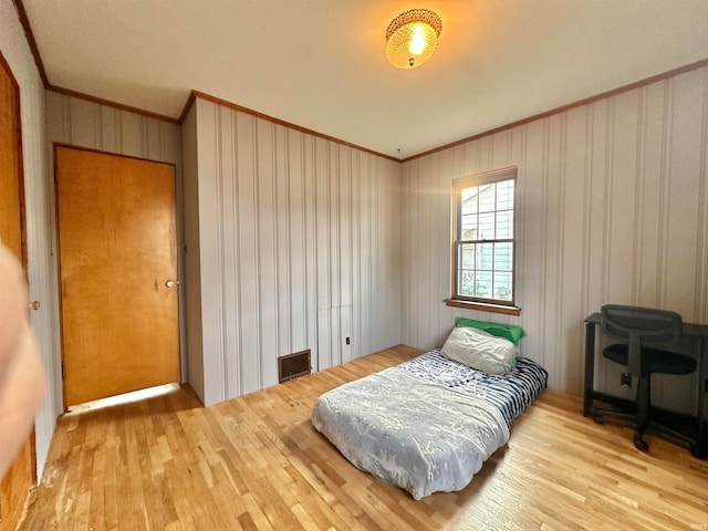 bedroom featuring light hardwood / wood-style floors and crown molding