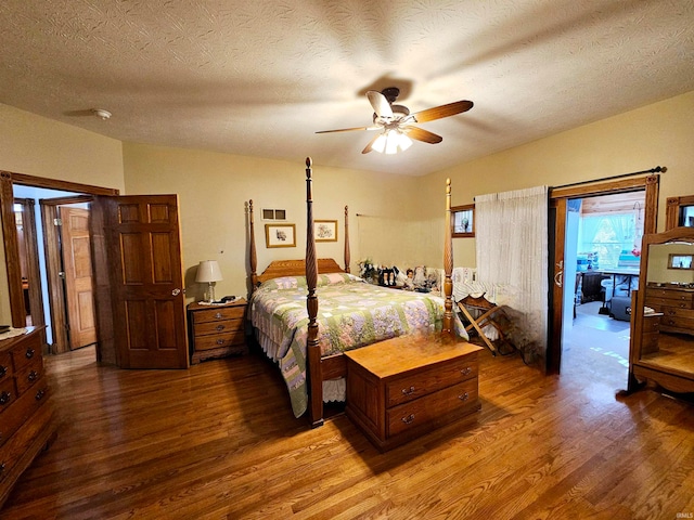 bedroom with hardwood / wood-style flooring, a textured ceiling, and ceiling fan