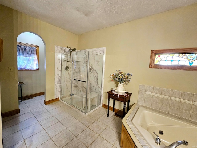 bathroom featuring a healthy amount of sunlight, tile patterned flooring, and plus walk in shower