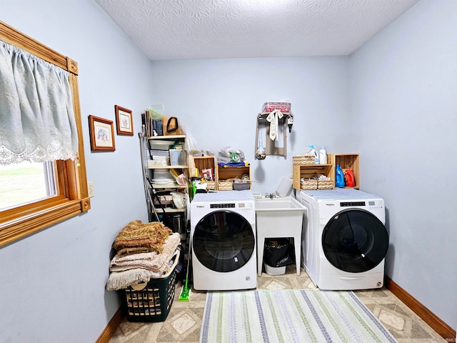 laundry area with a textured ceiling and washer and dryer