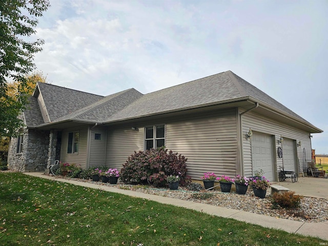 view of side of property with a lawn and a garage