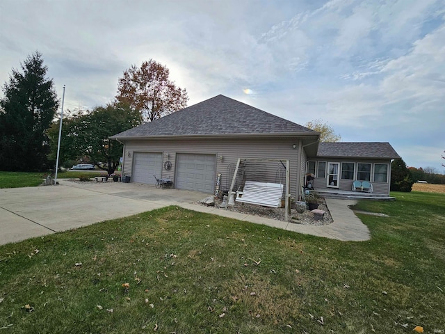 view of side of property with a lawn and a garage