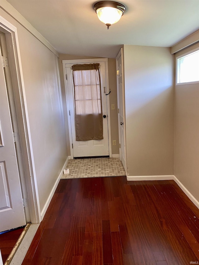 doorway featuring baseboards and hardwood / wood-style flooring