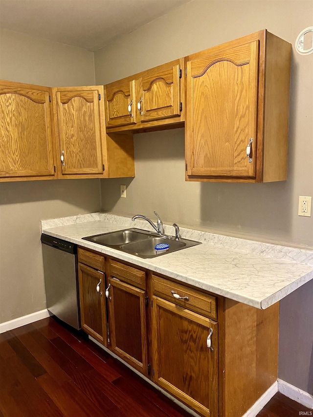 kitchen with light countertops, dishwasher, a sink, baseboards, and dark wood-type flooring