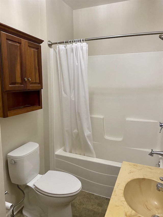 bathroom featuring shower / tub combo, toilet, and a sink