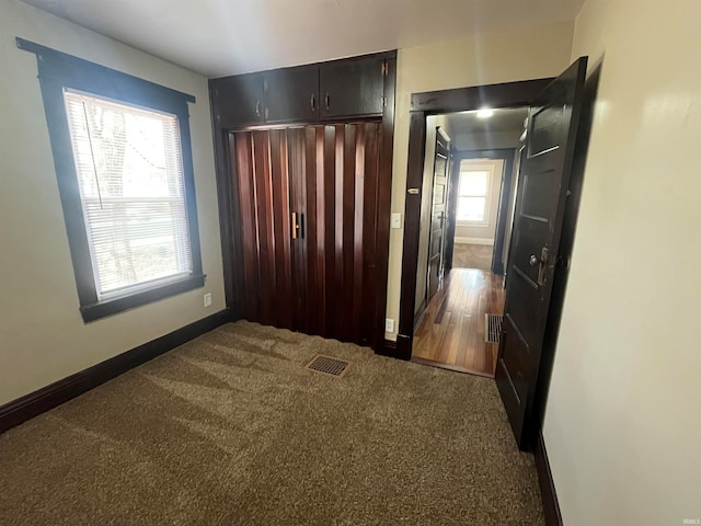 hall featuring dark hardwood / wood-style floors and a healthy amount of sunlight