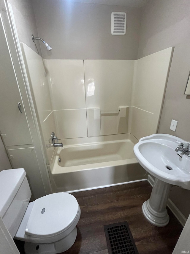 bathroom with toilet, hardwood / wood-style floors, and  shower combination