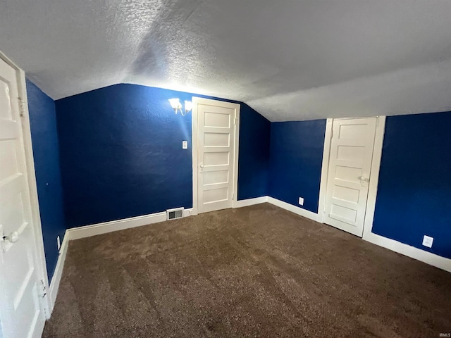 bonus room with lofted ceiling, carpet, and a textured ceiling