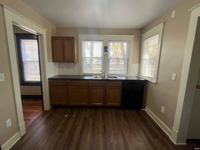 kitchen with decorative backsplash, dishwasher, sink, and dark wood-type flooring