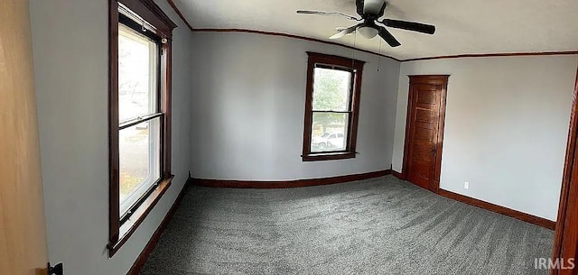 empty room featuring ornamental molding, vaulted ceiling, carpet floors, and ceiling fan