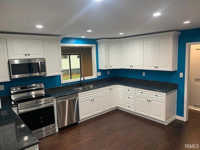 kitchen featuring white cabinetry, appliances with stainless steel finishes, sink, and dark hardwood / wood-style flooring