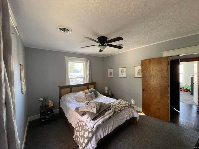 bedroom with dark hardwood / wood-style floors, a textured ceiling, and ceiling fan