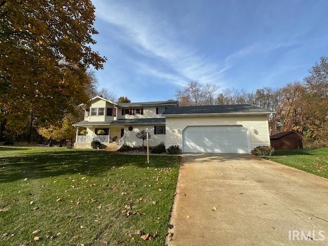 view of front of home featuring a garage, a front lawn, and a porch