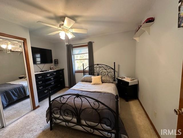 carpeted bedroom with a closet and ceiling fan