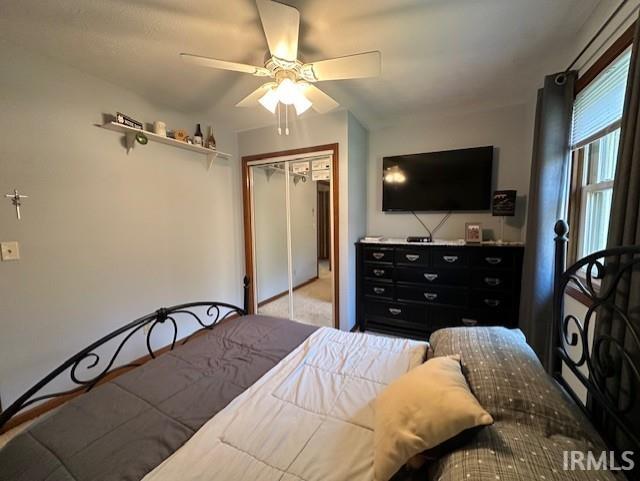 bedroom with ceiling fan and a closet