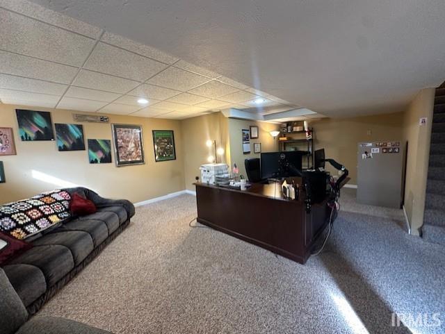 carpeted office space featuring a paneled ceiling