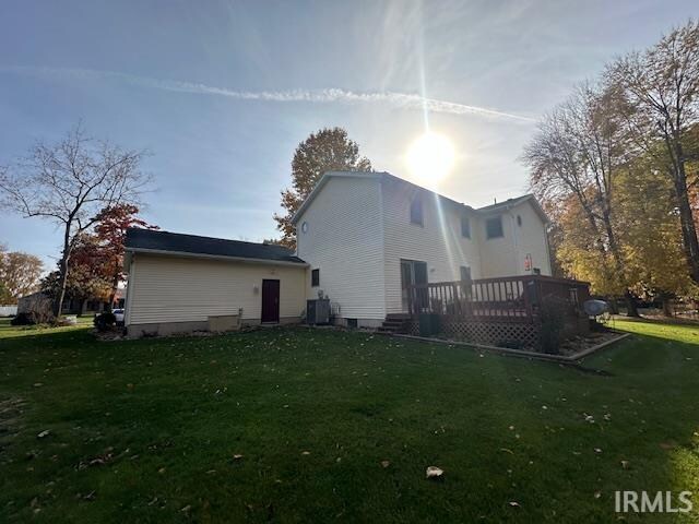 rear view of property with a wooden deck, a yard, and central AC unit