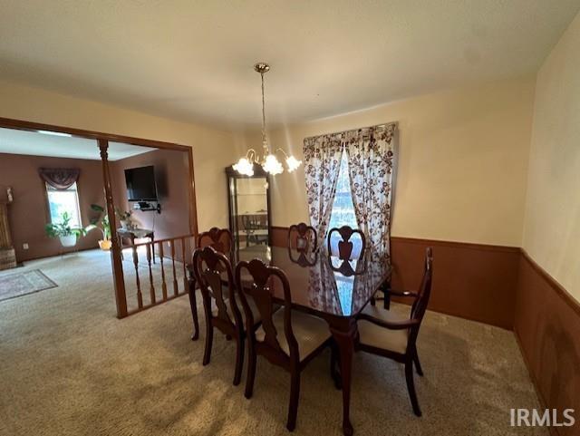 dining room featuring carpet floors and a notable chandelier