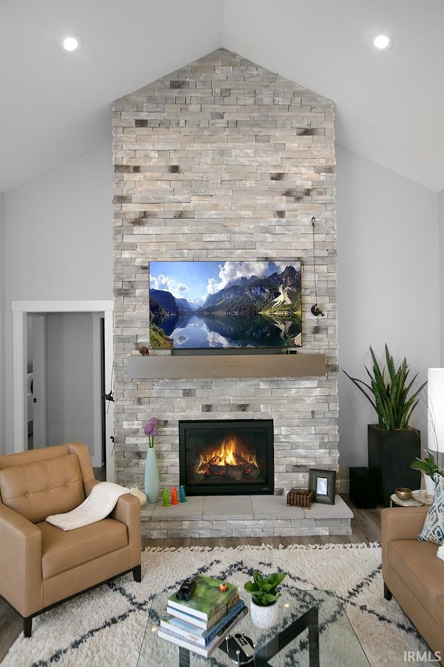 living room with hardwood / wood-style floors, a fireplace, and vaulted ceiling