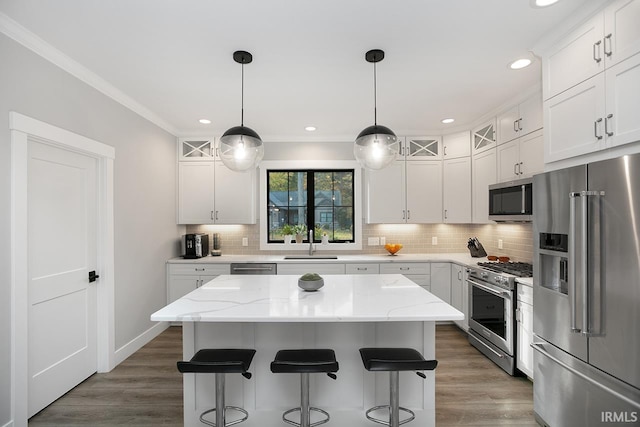 kitchen with high end appliances, a kitchen island, and white cabinets