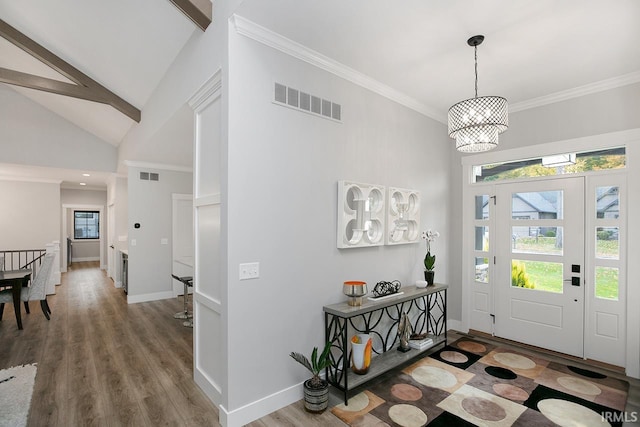 entryway featuring an inviting chandelier, ornamental molding, hardwood / wood-style flooring, and high vaulted ceiling