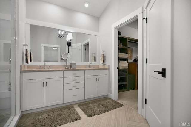 bathroom featuring vanity, a notable chandelier, and a shower with door