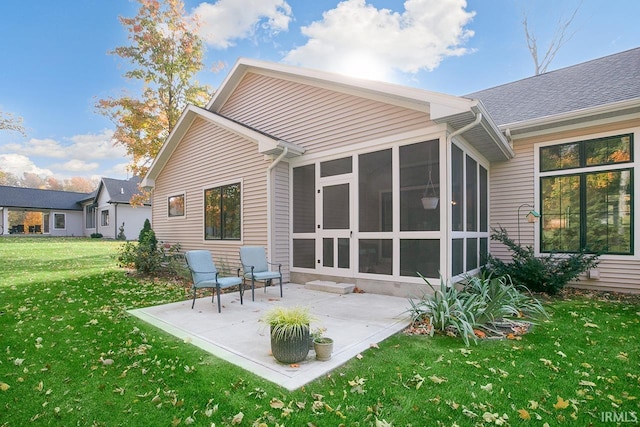 rear view of house with a patio area, a sunroom, and a lawn