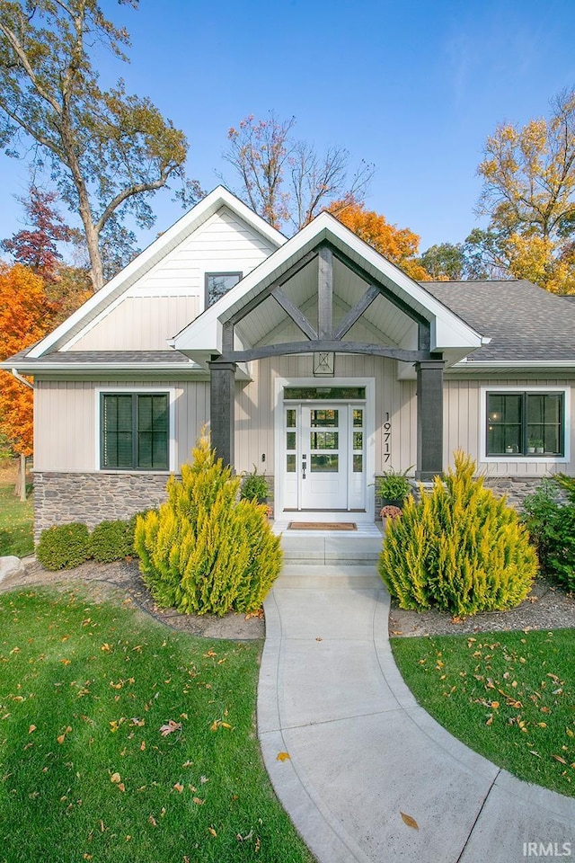 entrance to property with a porch and a lawn