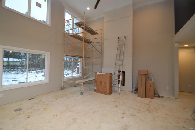 unfurnished living room featuring a towering ceiling