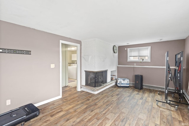 workout room featuring washer / dryer, hardwood / wood-style floors, and a fireplace