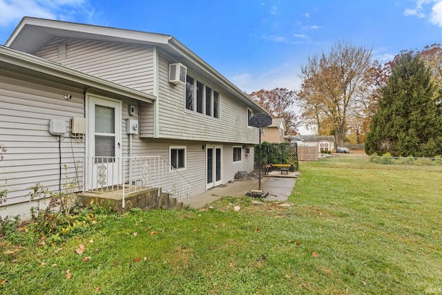 rear view of property with a patio, a lawn, and a wall mounted air conditioner