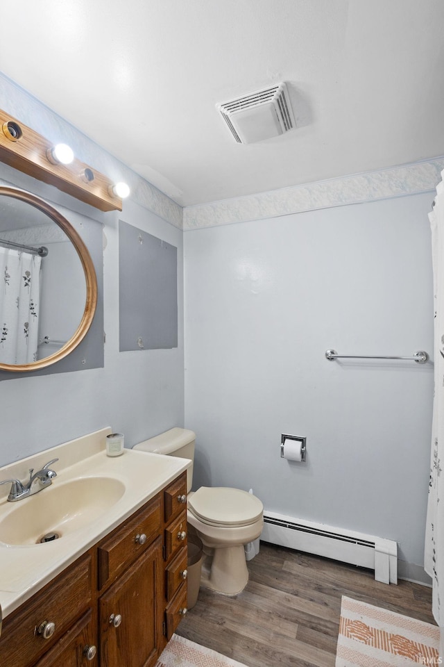 bathroom featuring baseboard heating, vanity, hardwood / wood-style floors, and toilet