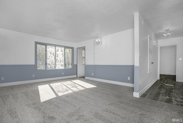 unfurnished room with an inviting chandelier and dark colored carpet