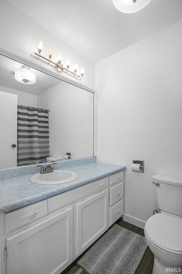 bathroom with vanity, toilet, hardwood / wood-style flooring, and walk in shower