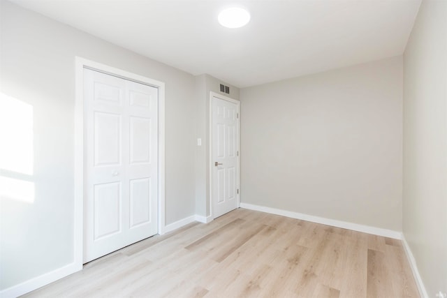 unfurnished bedroom with light hardwood / wood-style floors and a closet