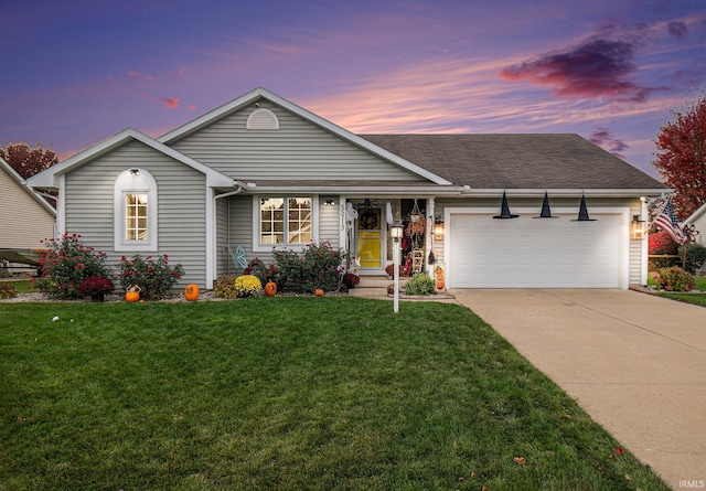 single story home featuring a lawn and a garage